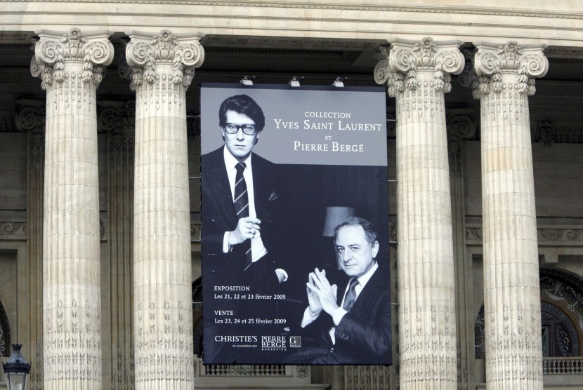 Poster yang dipasang di Grand Palais menunjukkan foto pendiri rumah mode Yves Saint Laurent dan mitranya Pierre Barge.