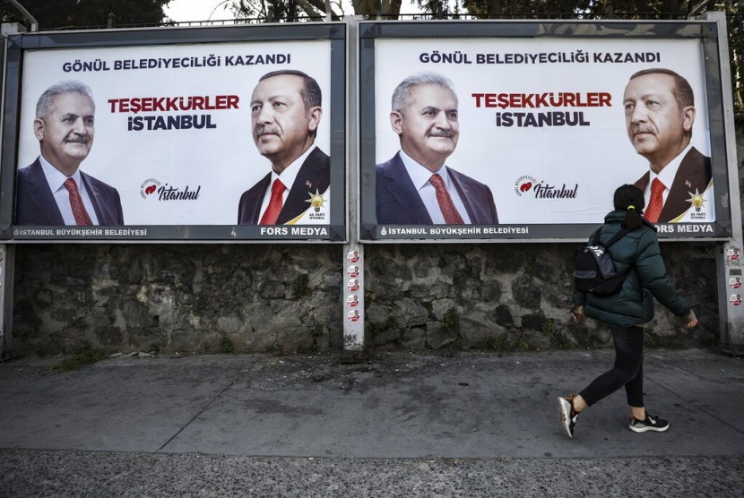 Poster yang menunjukkan gambar diri kandidat wali kota Istanbul Binali Yildirim (kiri) dan Presiden Turki Recep Tayyip Erdogan yang merupakan pemimpin AK Party, sehari setelah pemilihan lokal di Istanbul, Senin (1/4). 
