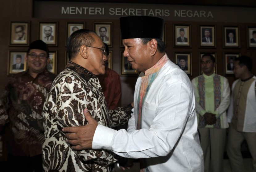 Prabowo Subianto (kanan) bersalaman dengan Ketua Umum Partai Golkar Aburizal Bakrie (kiri) sebelum mengikuti acara open house Idul Fitri 1435 H di Istana Negara, Jakarta, Senin (18/7). 