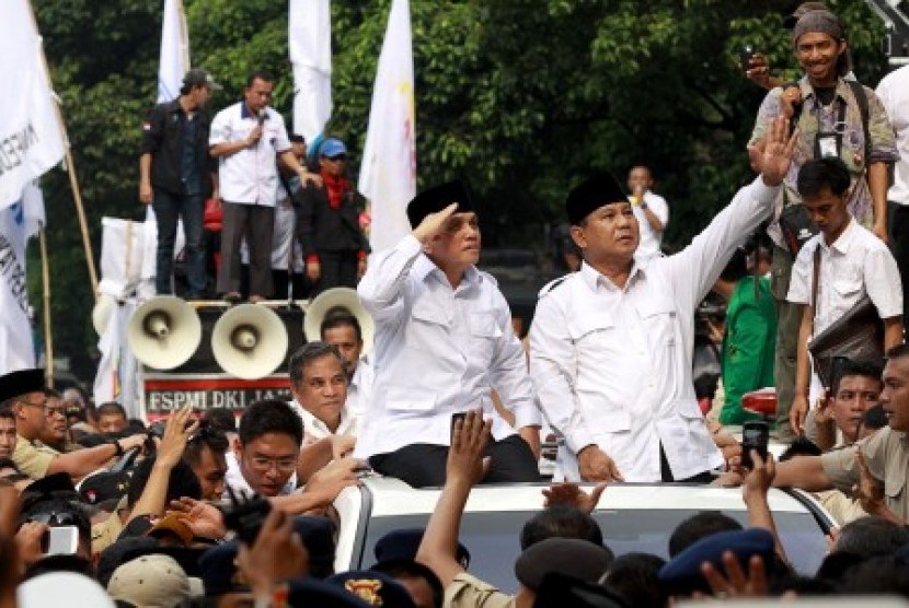 Prabowo Subianto (kanan) dan Hatta Rajasa (kiri) menyapa pendukungnya saat meninggalkan gedung KPU usai menyerahkan berkas-berkas kelengkapan pendaftaran untuk mengikuti Pilpres di halaman Gedung KPU, Jakpus, Selasa (20/5). 