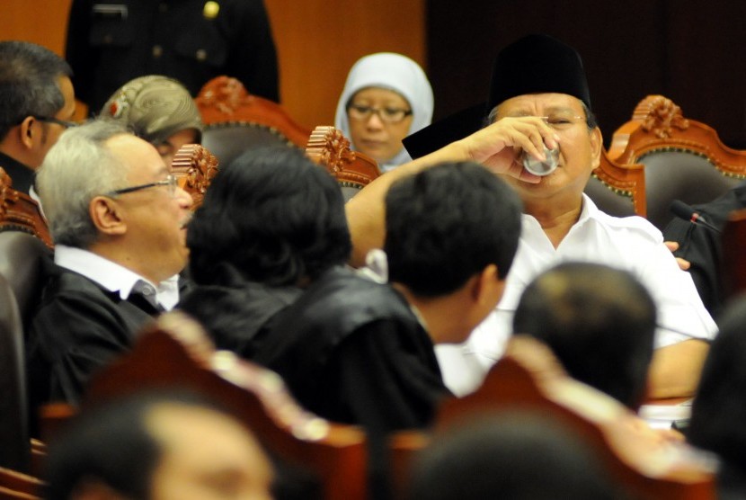 Prabowo Subianto (kanan) minum air jelang sidang perdana perkara Perselisihan Hasil Pemilihan Umum (PHPU) Presiden dan Wakil Presiden Tahun 2014 di Mahkamah Konstitusi (MK), Jakarta, Rabu (6/8). 