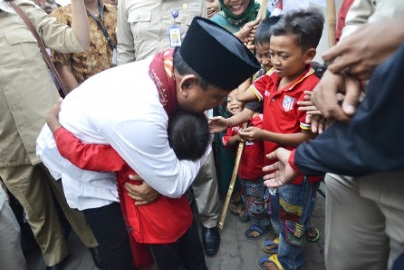 Prabowo Subianto memeluk seorang anak saat mengunjungi kontrakan seribu pintu di kawasan industri Jababeka, Cikarang, Bekasi, Jabar, Senin (7/7). 
