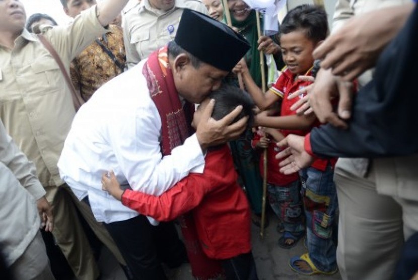 Prabowo Subianto mencium kening seorang anak saat mengunjungi kontrakan seribu pintu di kawasan industri Jababeka, Cikarang, Bekasi, Jabar, Senin (7/7). 