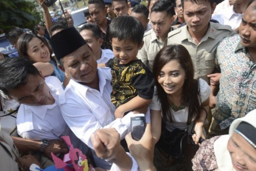 Prabowo Subianto menggendong anak kecil seusai menggunakan hak pilihnya di TPS 02, Bojong Koneng, Bogor, Jabar, Rabu (9/2). 