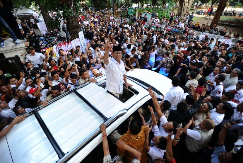 Prabowo Subianto menyapa relawan saat akan meninggalkan rumah Polonia, Jakarta, Selasa (22/7).