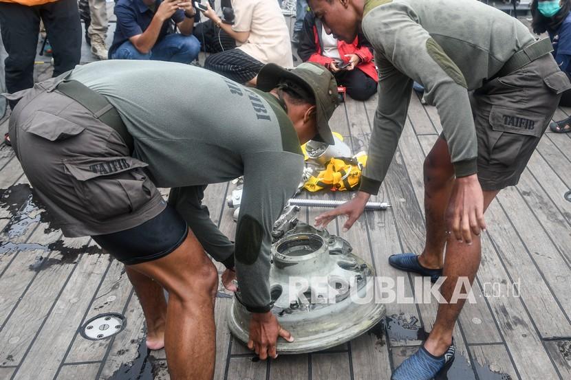 Prajurit Batalyon Intai Amfibi-1 Korps Marinir (Yontaifib) membawa puing pesawat Sriwijaya Air nomor penerbangan SJ182 yang mengalami kecelakaan ke atas KRI Rigel-933 saat lego jangkar di perairan Kepulauan Seribu, Jakarta, Rabu (13/1/2021). Petugas SAR gabungan pada hari kelima terus melakukan pencarian dari puing dan korban dari pesawat Sriwijaya Air SJ182 yang jatuh di antara Pulau Laki dan Pulau Lancang pada Sabtu (9/1/2021).