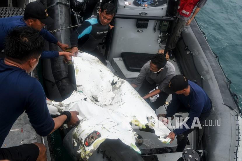 Prajurit Detasemen Jala Mangkara (Denjaka) Korps Marinir TNI AL membawa puing pesawat Sriwijaya Air nomor penerbangan SJ182 yang mengalami kecelakaan ke atas KRI Rigel-933 saat lego jangkar di perairan Kepulauan Seribu, Jakarta, Rabu (13/1/2021). Petugas SAR gabungan pada hari kelima terus melakukan pencarian dari puing dan korban dari pesawat Sriwijaya Air SJ182 yang jatuh di antara Pulau Laki dan Pulau Lancang pada Sabtu (9/1/2021). 