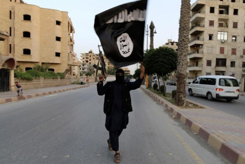 Prajurit ISIS mengibarkan panji kebesarannya.