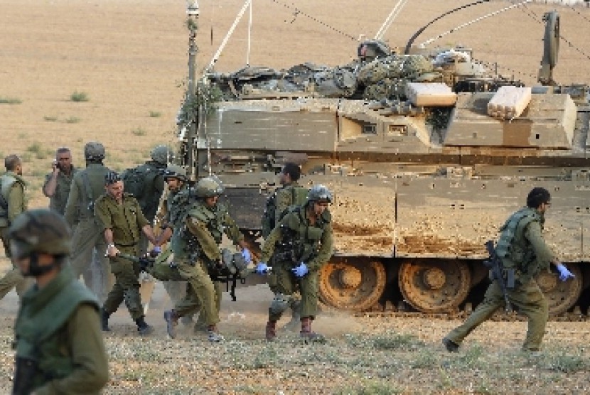 Prajurit militer Israel memboyong rekannya yang terluka.