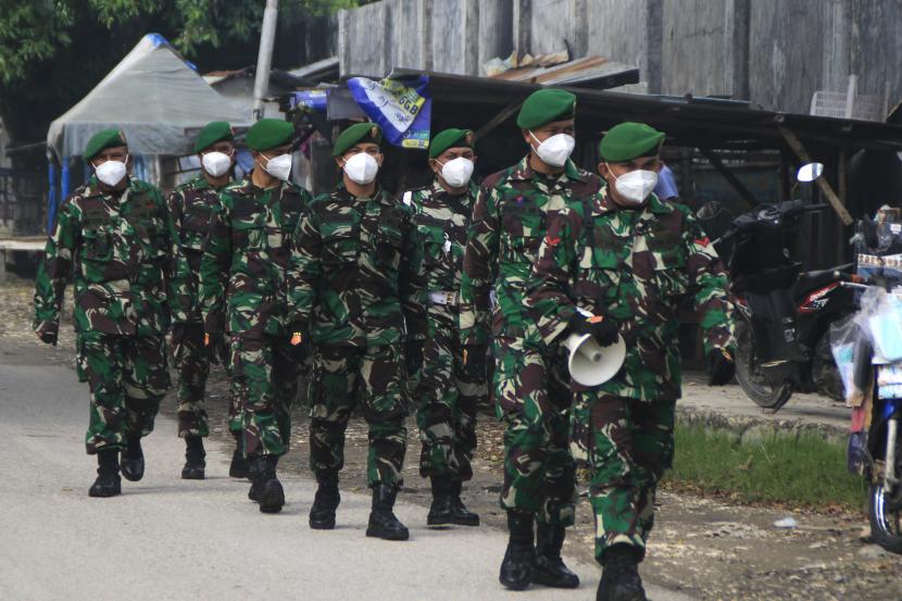 Prajurit TNI AD berjalan bersama saat mengelar operasi Yustisi di Pasar Oeba, Kota Kupang, Rabu (10/2/2021). Operasi Yustisi yang dilakukan oleh aparat TNI dan Polri tersebut guna menekan angka penyebaran COVID-19 di Kota Kupang.