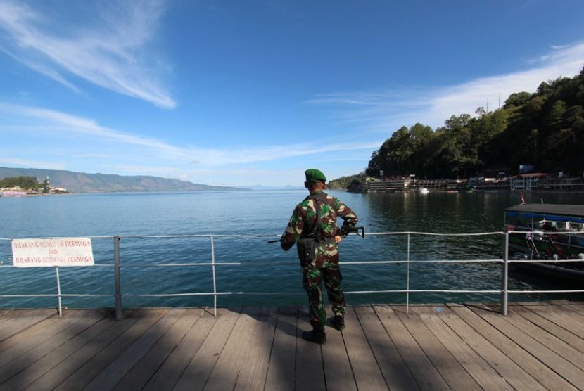 Prajurit TNI AD berpatroli di kawasan Pantai Bebas Danau Toba, Parapat, untuk pengamanan Karnaval Kemerdekaan HUT Ke-71 RI yang dihadiri Presiden Joko Widodo.