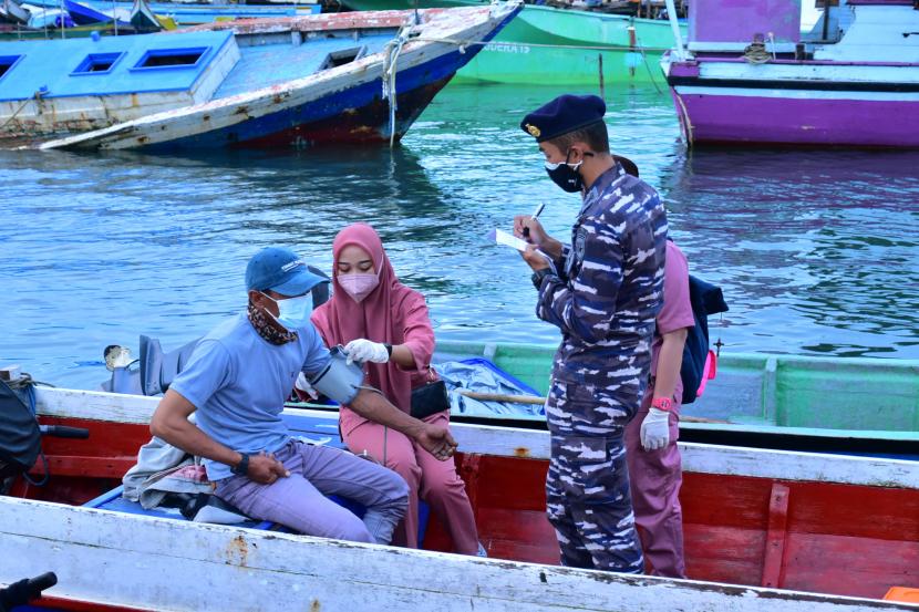 Prajurit TNI AL dan tenaga kesehatan mendata dan melakukan pemeriksaan kesehatan kepada nelayan di dermaga Tempat Pelelangan Ikan (TPI) di Jembatan Puri, Kota Sorong, Papua Barat, Kamis (9/9/2021). Dalam rangka memperingati HUT ke-76 TNI AL, Lantamal XIV Sorong menggelar vaksinasi COVID-19 dengan sasaran nelayan dan masyarakat maritim guna mengejar target capaian vaksinasi di Papua Barat yang baru mencapai 42,4 persen dari target 797.402 orang.