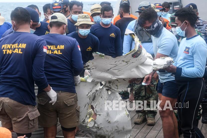 Prajurit TNI AL mengangkat puing pesawat Sriwijaya Air nomor penerbangan SJ182 yang mengalami kecelakaan di KRI Rigel-933 saat lego jangkar di perairan Kepulauan Seribu, Jakarta, Rabu (13/1/2021). Petugas SAR gabungan pada hari kelima terus melakukan pencarian dari puing dan korban dari pesawat Sriwijaya Air SJ182 yang jatuh di antara Pulau Laki dan Pulau Lancang pada Sabtu (9/1/2021).