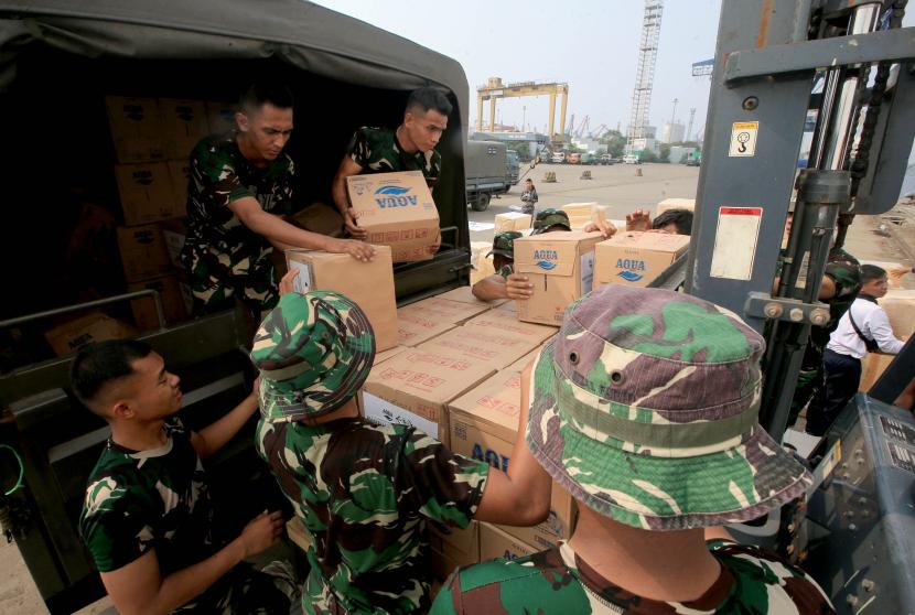 Prajurit TNI AL mengangkut botol Aqua yang akan dikirimkan ke Palestina melalui Kapal Rumah Sakit dr Radjiman Wedyodiningrat-992 di Pelabuhan Tanjung Priok, Jakarta Utara, Selasa (12/12/2023).