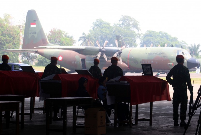 Prajurit TNI AU berdiri disamping peti jenazah prajurit TNI yang menjadi korban jatuhnya pesawat Hercules C-130 saat proses pengembalian jenazah korban di Lanud Soewondo Medan, Sumatera Utara, Rabu (1/7). (Antara//Septianda Perdana)