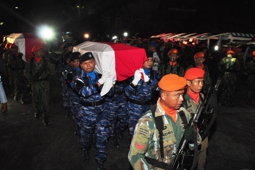 Prajurit TNI AU menggotong peti jenazah korban kecelakaan pesawat Hercules A-1334 untuk disemayamkan di Hanggar Skadron 32 Lanud Abdulrahman Saleh, Malang, Jawa Timur, Minggu (18/12) malam. 