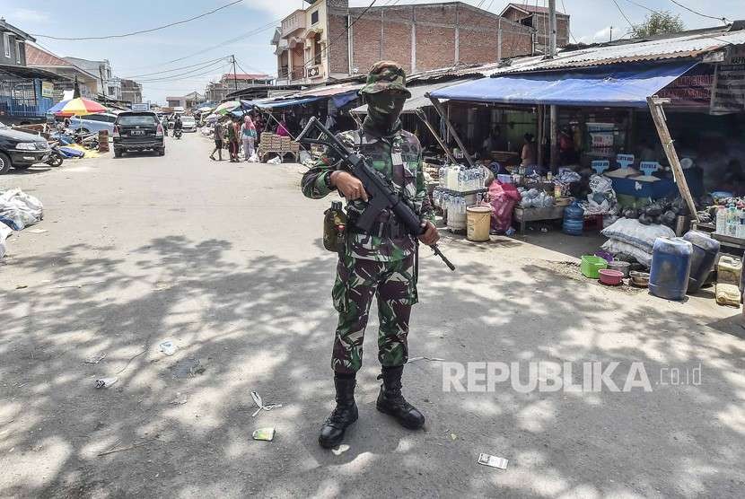 Prajurit TNI berjaga di depan toko milik warga di Pasar Masomba, Palu, Sulawesi Tengah, Kamis (4/10).