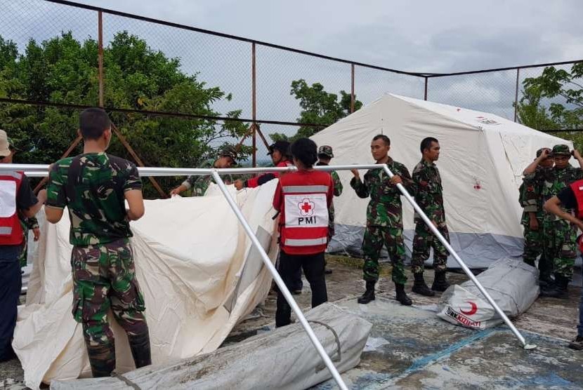 Prajurit TNI bersama dengan Palang Merah Indonesia (PMI) dan relawan membangun hunian sementara di wilayah Balaroa, Palu Barat, Palu, Sulawesi Tengah (Sulteng), Sabtu (13/10). 