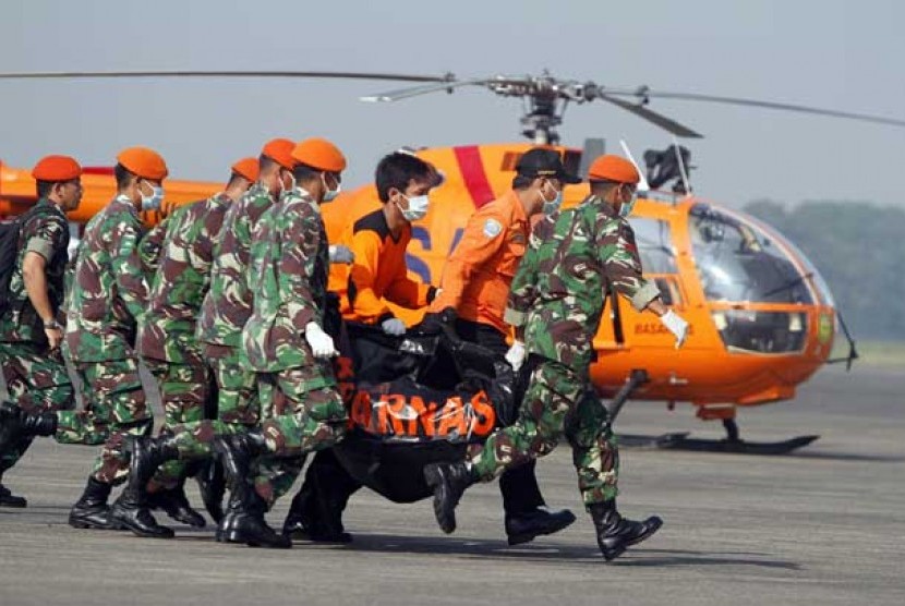 Prajurit TNI dan tim Basarnas membawa sebuah kantong yang berisi jenazah korban kecelakaan pesawat Sukhoi Super Jet 100 menuju mobil ambulance di Bandara Halim Perdanakusuma, Jakarta, Sabtu (12/5).