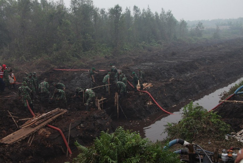 Prajurit TNI dikerahkan untuk membuat sekat kanal di lahan yang terbakar.