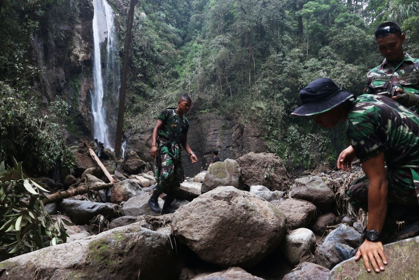 Prajurit TNI melakukan proses pencarian korban banjir bandang dilokasi wisata Air Terjun Dua Warna, Sibolangit, Deli Serdang, Sumatera Utara, Selasa (17/5).