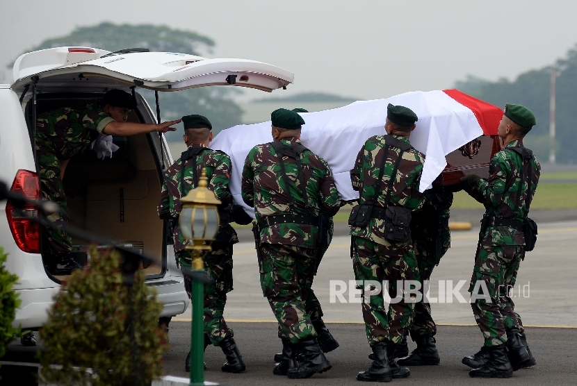  Prajurit TNI memasukan jenazah KH Hasyim Muzadi usai dilakukannya upacara militer di Lanud Halim Perdanakusuma, Jakarta, Kamis (16/3). 