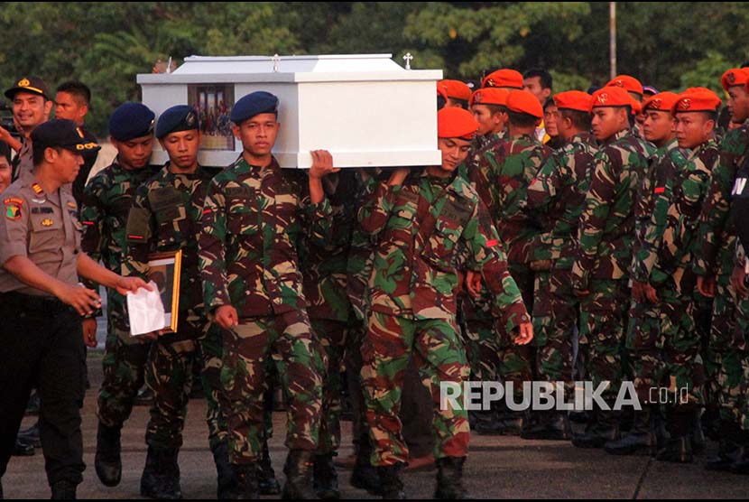 Prajurit TNI mengangkat peti jenazah korban penembakan kelompok kriminal bersenjata (KKB) yang tiba di Landasan Udara Hasanuddin, Kabupaten Maros, Sulawesi Selatan, Jumat (7/12). Sebanyak 16  jenazah korban penembakan KKB di Nduga dipulangkan dan  diserahterimakan kepada pihak keluarga.