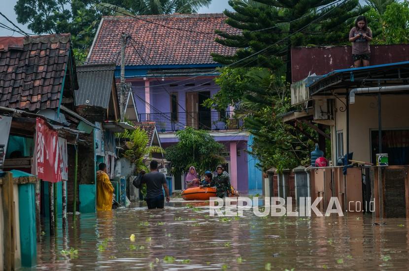 Prajurit TNI mengevakuasi warga saat banjir di Rangkasbitung, Lebak, Banten, Selasa (14/9/2021). Tingginya intensitas hujan yang terjadi sejak Senin (13/9/2021) malam, menyebabkan ratusan rumah di Rangkasbitung terendam banjir setinggi dua meter.