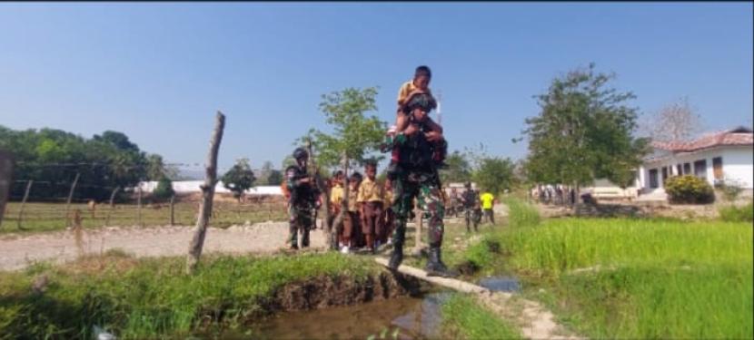 Prajurit TNI menggendong anak di perbatasan