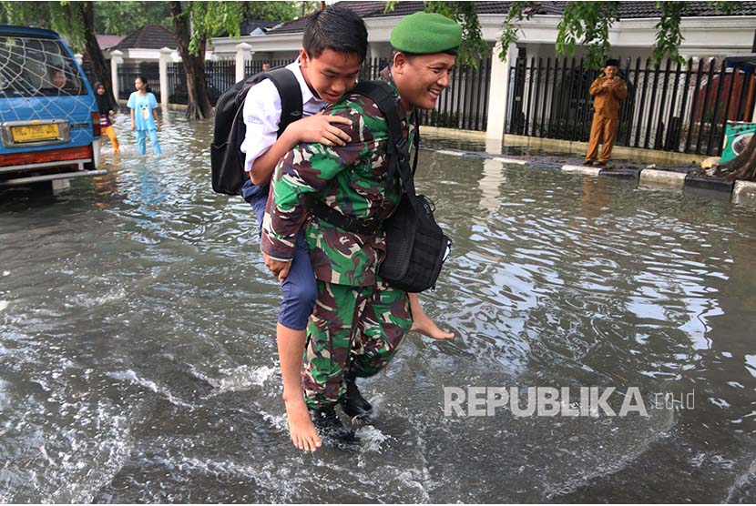 Prajurit TNI menggendong seorang siswa SMPsaat banjir. (Ilustrasi)