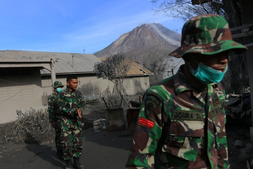 Prajurit TNI menyisir kawasan yang terkena dampak awan panas erupsi Gunung Sinabung di Desa Gamber, Karo, Sumatra Utara,  Ahad (22/5). (Antara/Irsan Mulyadi)