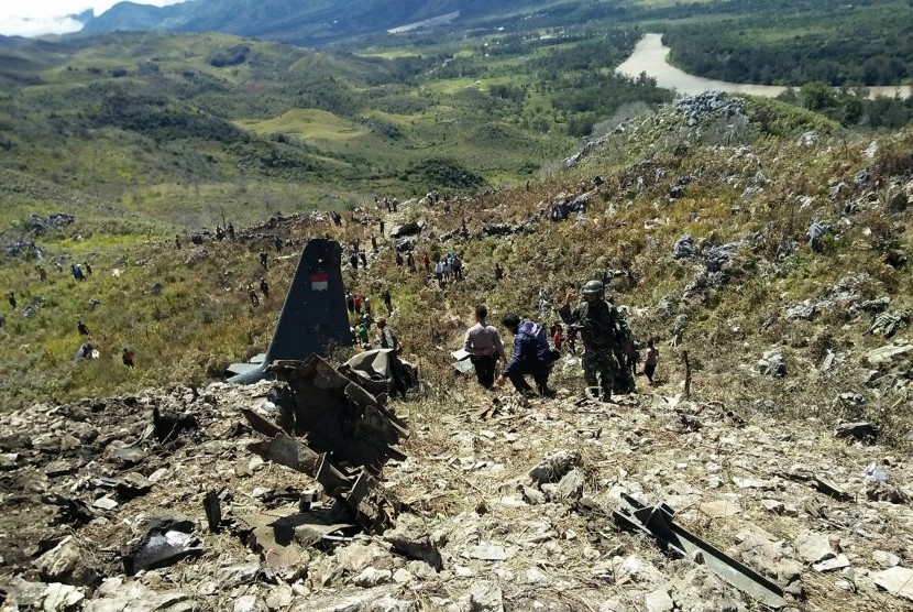 Prajurit TNI, Polri dan warga mengevakuasi puing pesawat Hercules yang jatuh di kawasan Gunung Lisuwa, Kampung Maima, Distrik Minimo, Kabupaten Jayawijaya, Minggu (18/12). 