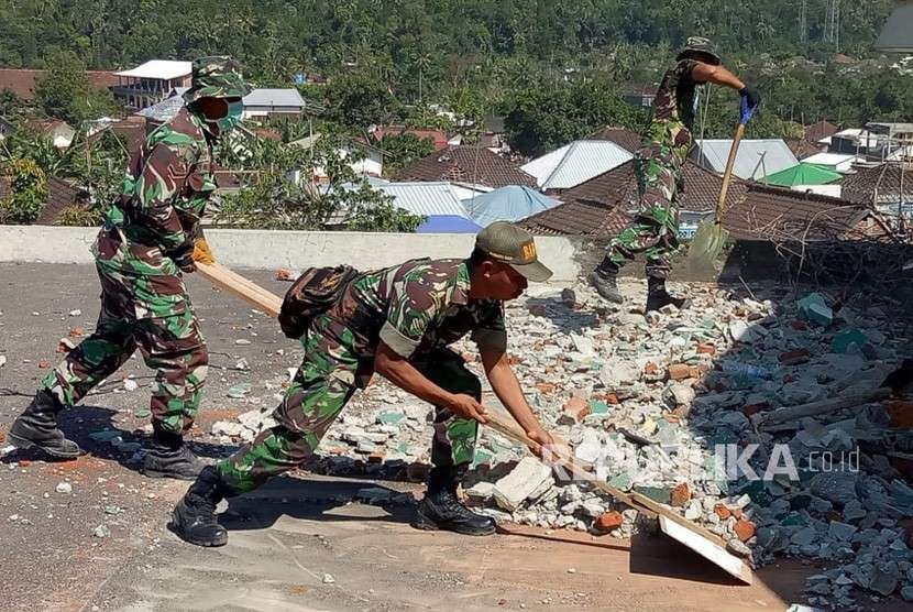 Prajurit TNI yang tergabung dalam Komando Tugas Gabungan Terpadu (Kogasgabpad) bersama warga membongkar dan membersihkan puing-puing Masjid Al-Abror di Dusun Wadon,  Desa Kekait,Kecamatan Gunung Sari, Lombok Barat, Senin (24/9).