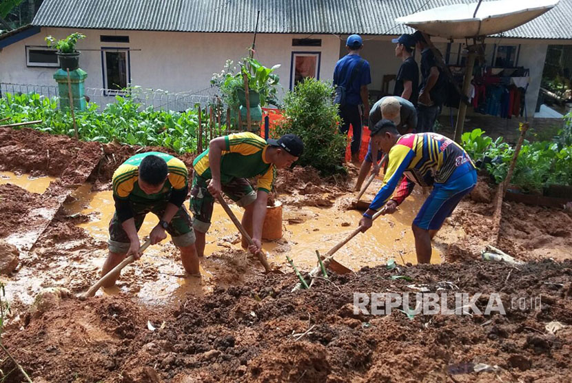 Prajurit Yonif Raider 323 Kostrad membantu korban bencana alam banjir dan tanah longsor di Pangandaran.