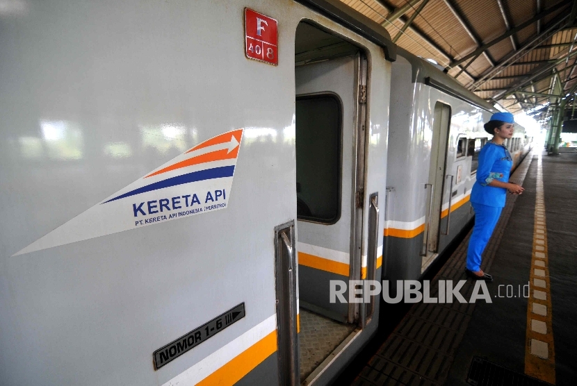 Pramugari mengarahkan penumpang di Stasiun Gambir.