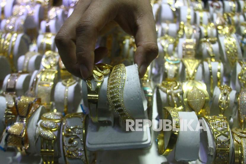 Pramuniaga menata gelang emas di sebuah gerai perhiasan di Malang, Jawa Timur, Senin (10/1/2022). Kontrak emas paling aktif untuk pengiriman April di divisi Comex New York Exchange, melonjak 30,50 dolar AS atau 1,63 persen.