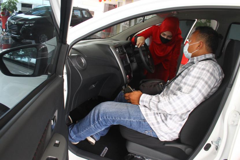 Pramuniaga menjelaskan fitur mobil kepada konsumen di diler Toyota Auto2000, Malang, Jawa Timur.