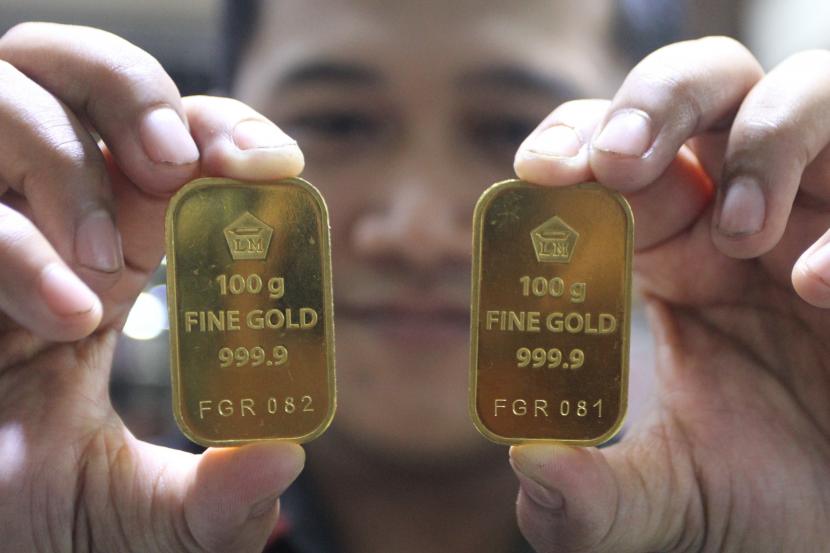 Pramuniaga menunjukkan emas batangan Aneka Tambang (Antam) untuk investasi di sebuah gerai emas di Malang, Jawa Timur, Selasa (12/7/2022). 