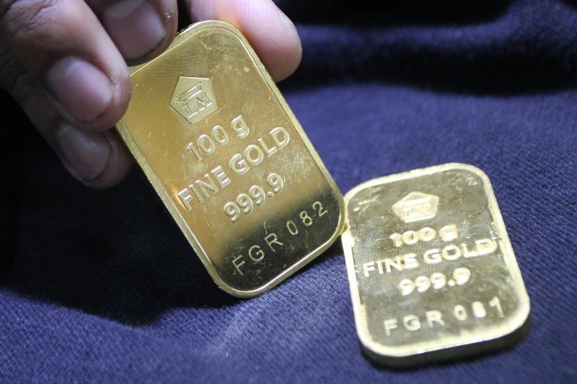 Pramuniaga menunjukkan emas batangan Aneka Tambang (Antam) untuk investasi di sebuah gerai emas di Malang, Jawa Timur, Selasa (12/7/2022). Harga emas batangan dari Logam Mulia PT Aneka Tambang Tbk (Antam) bergerak datar pada hari ini, Selasa (23/5/2023).