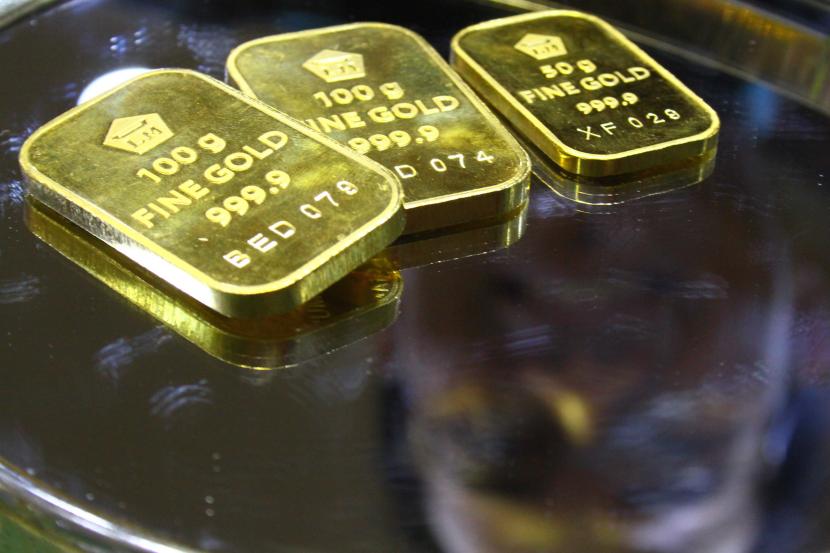 Pramuniaga menunjukkan emas untuk investasi atau batangan Antam di sebuah gerai emas di Malang, Jawa Timur, Kamis (10/3/2022). Harga emas batangan dari Logam Mulia PT Aneka Tambang Tbk (Antam) mengalami kenaikan pada hari ini, Rabu (29/3/2023).
