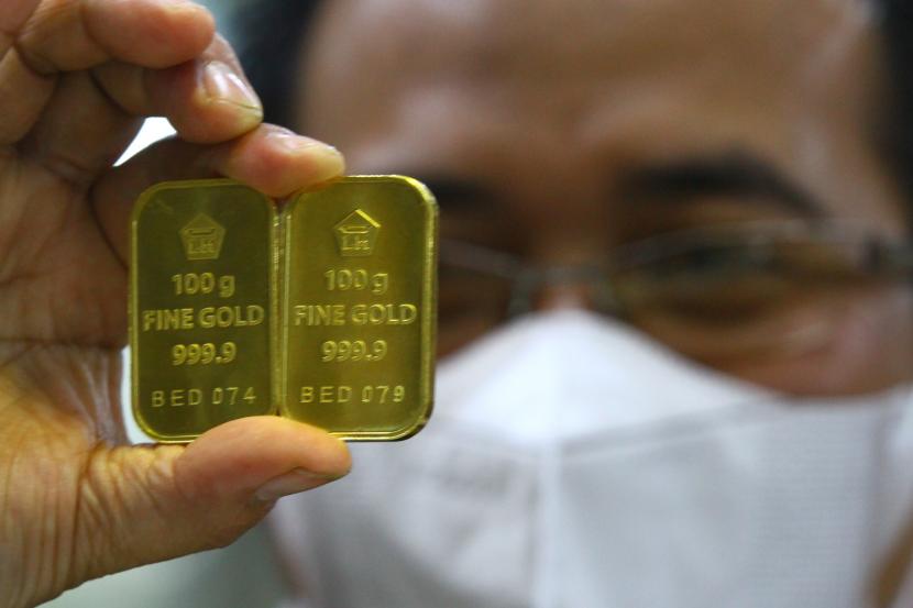 Pramuniaga menunjukkan emas Antam di sebuah gerai emas di Malang, Jawa Timur, Kamis (10/3/2022) (ilustrasi). Harga emas batangan dari Logam Mulia PT Aneka Tambang Tbk (Antam) mengalami penurunan pada Rabu (15/3/2023).