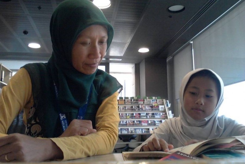 Pratiwi menemani putrinya Adzra membaca di sebuah perpustakaan di Melbourne.