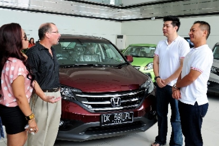 Presdir PT Honda Prospect Motor (HPM) Tomoki Uchida (kanan) bersama Direktur Pemasaran dan Layanan Purnajual Jonfis Fandy (dua kanan) berbincang dengan pembeli 