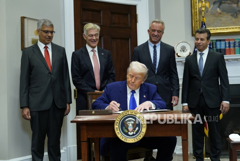 Presiden Amerika Serikat Donald J. Trump (tengah) menandatangani perintah eksekutif selama konferensi pers di Ruang Roosevelt Gedung Putih di Washington, DC, AS, 12 Mei 2025.
