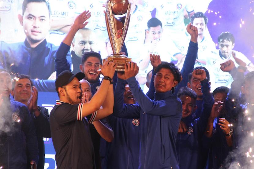 Presiden Arema FC Gilang Widya Permana (kiri) dan kapten tim Arema FC Johan Al Farisy (kanan) mengangkat trofi Piala Presiden saat Peluncuran Tim dan Jersey di Stadion Gajayana, Malang, Jawa Timur, Rabu (20/7/2022). Arema kembali menargetkan juara dalam kompetisi Liga 1 yang mulai bergulir pada 23 Juli 2022.