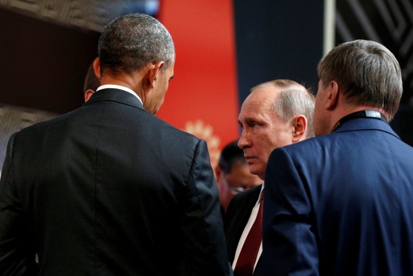 Presiden AS Barack Obama (kiri) berbicara dengan Presiden Rusia Vladimir Putin (tengah) dalam pertemuan APEC, Ahad (20/11).