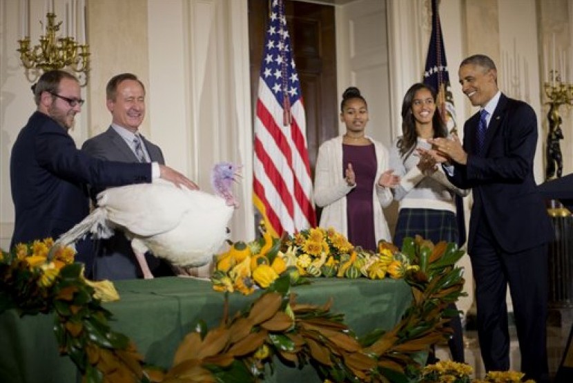 Presiden AS Barrack Obama ditemani putrinya Sasha dan Malia menyaksikan tradisi pengampunan ayam kalkun. Tradisi ini merupakan bagian dari hari raya Thanksgiving di AS.