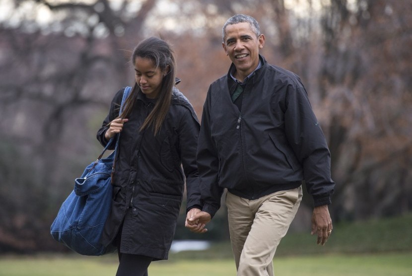 Presiden AS Barrack Obama menggandeng tangan putri tertuanya, Malia.