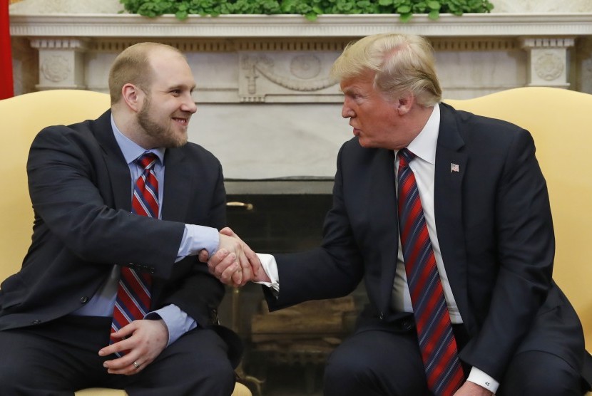 Presiden AS Donald Trump berjabat tangan dengan Joshua Holt, warga AS yang dibebaskan dari penjara Venezuela setelah dituduh menjadi mata-mata CIA di Amerika Latin. Keduanya bertemu di ruang Oval, Gedung Putih, Washington, Sabtu (26/5).