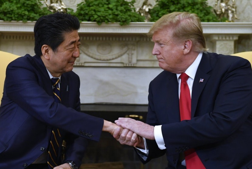 Presiden AS Donald Trump berjabat tangan dengan perdana menteri Jepang Shinzo Abe. 